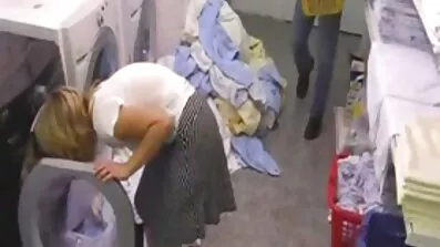 En halvnøgt blondine står foran et vindue og ser dansk sex video ud